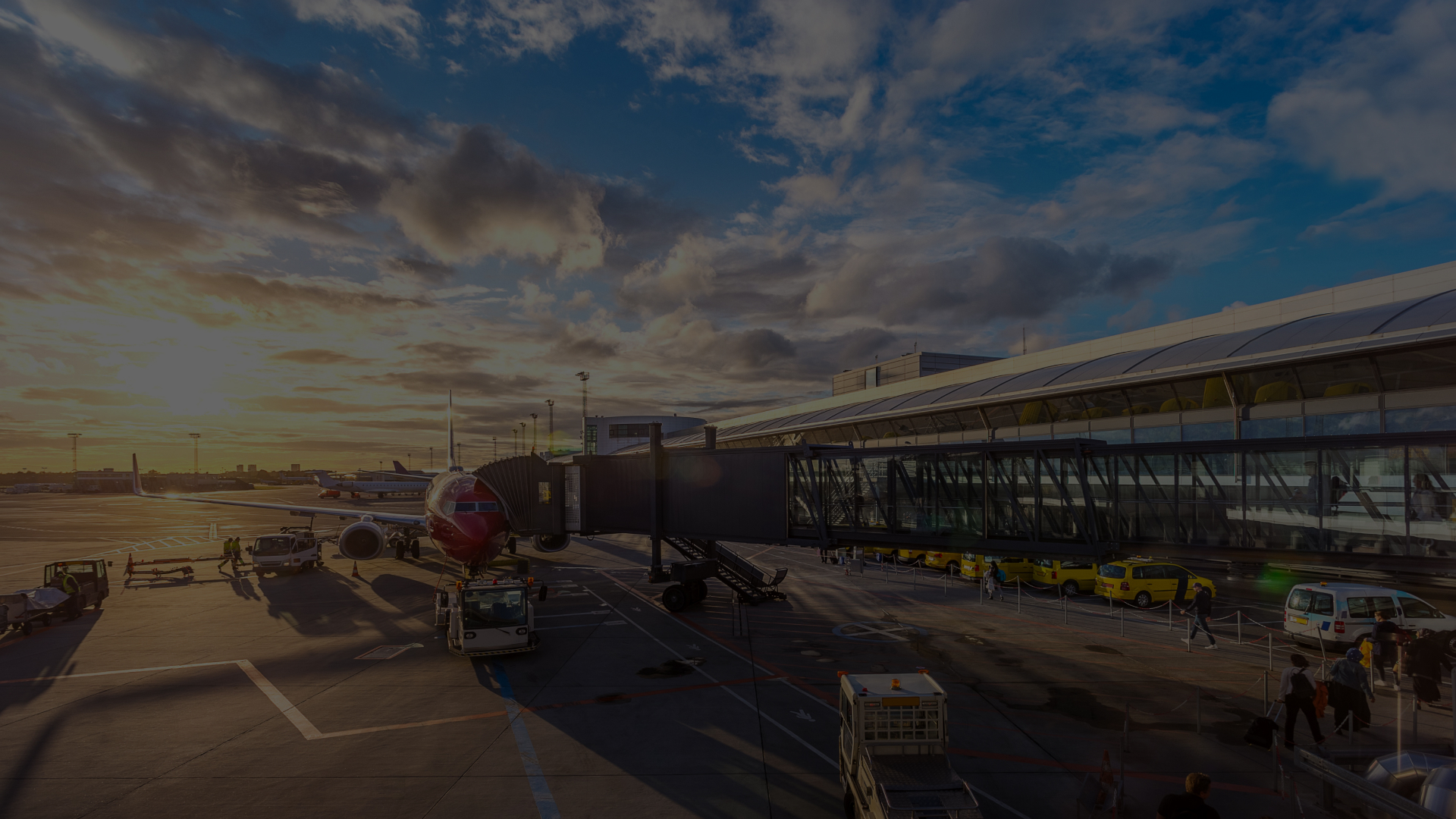 Airplane on tarmac at sunrise with terminal in view