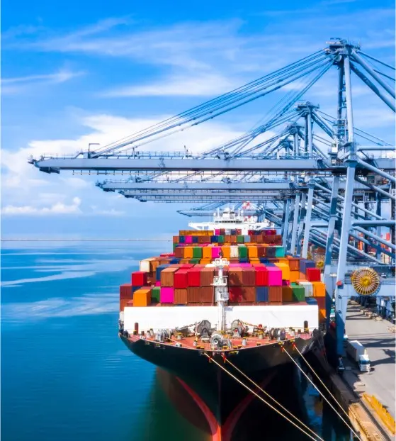 Colorful cargo ship docked at a port with cranes