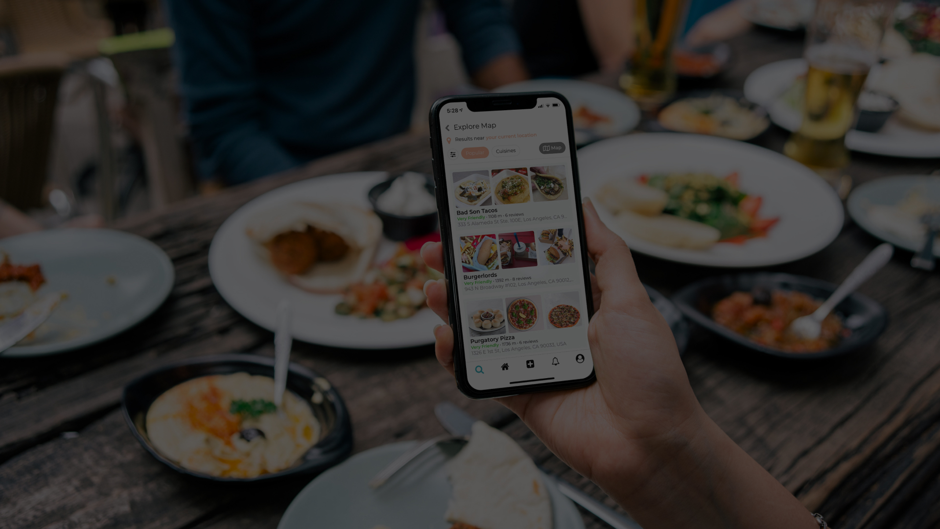 Person using a food delivery app at a restaurant table