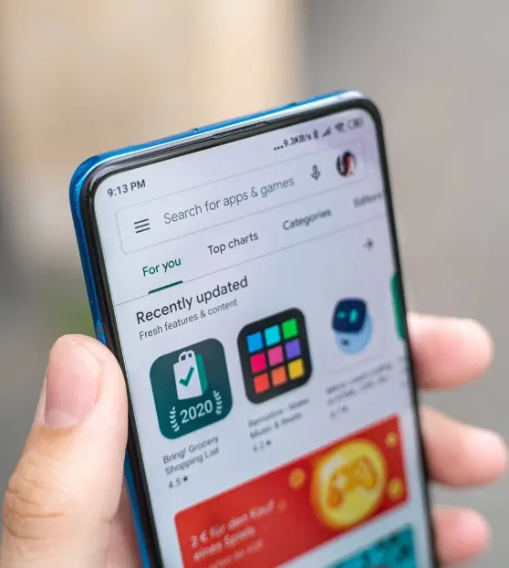 Person holding a smartphone with an app store screen