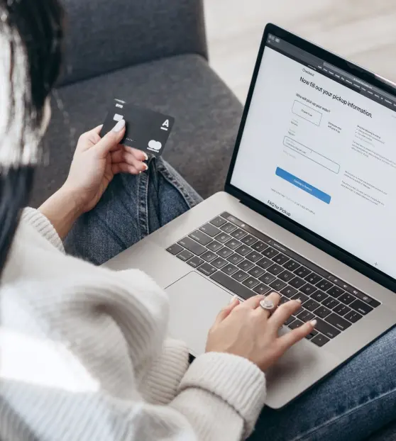 Person entering credit card details on a laptop for online payment