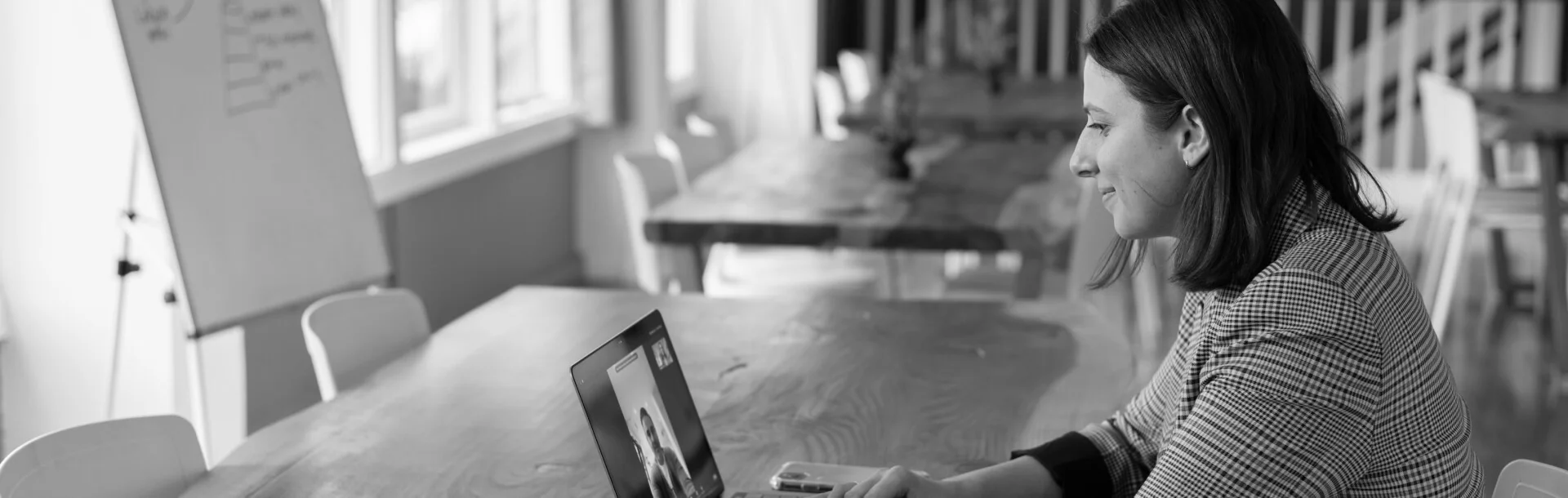Woman in a video conference call using a laptop in a modern office setting