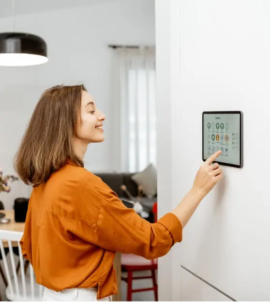 Woman using a wall-mounted smart home device