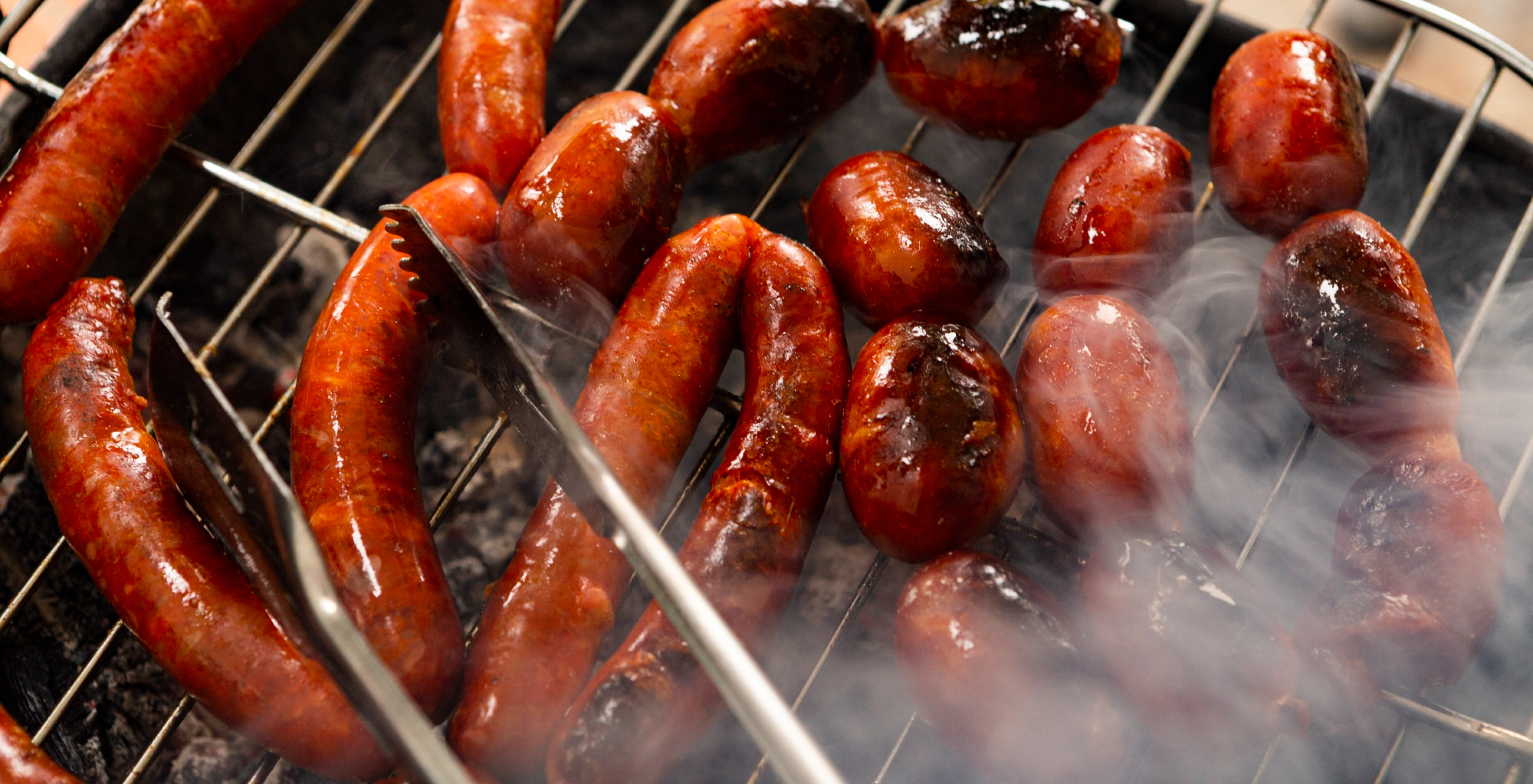 Grilled sausages on Kasai grill showcasing Shopify-powered ecommerce success